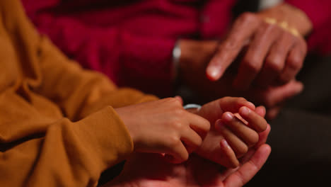 Close-Up-Of-Multi-Generation-Male-Sikh-Family-Wearing-And-Discussing-Traditional-Silver-Bangles-Or-Bracelets-Sitting-On-Sofa-At-Home-Shot-In-Real-Time